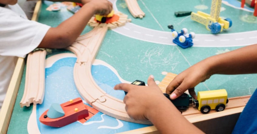 Boys with cars on play road.