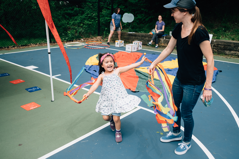 Picture: A young girl plays with colorful streamers while dancing around happily.