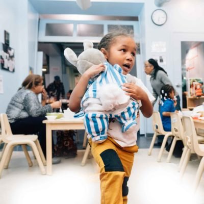 A child carries a large stuffed animal