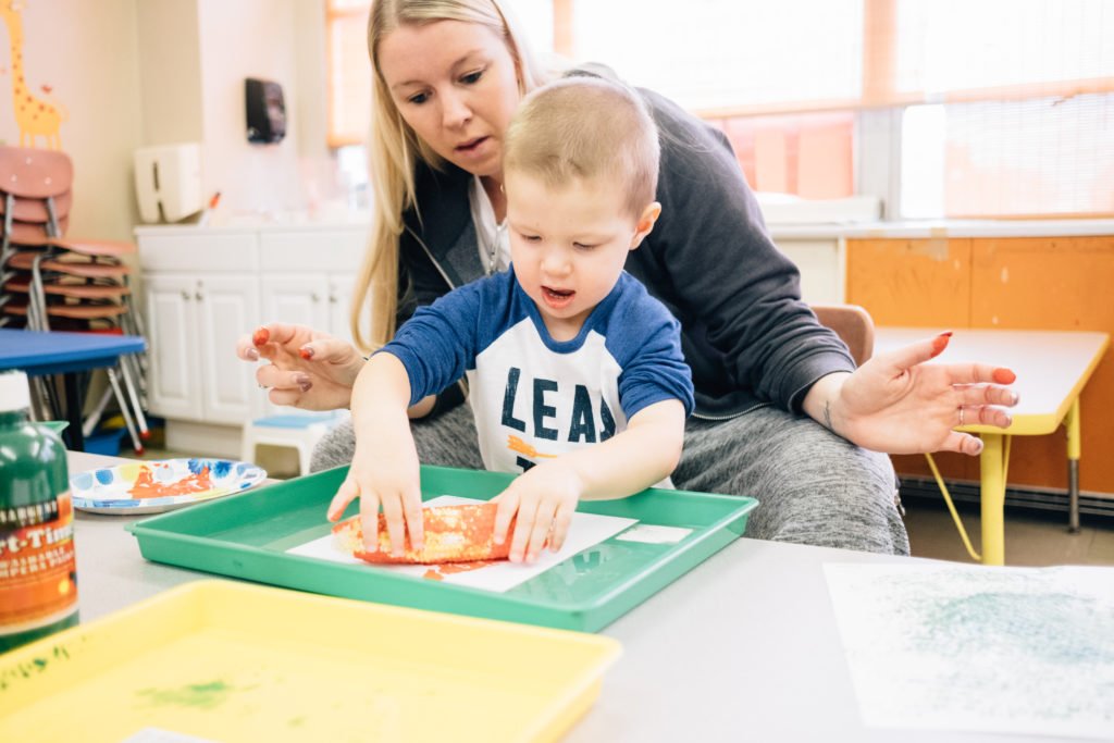 Woman and child playing at a table together | Pittsburgh LGBTQ+ youth