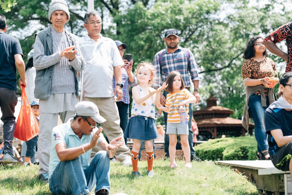 a group of people gathering at a park clapping | gender development