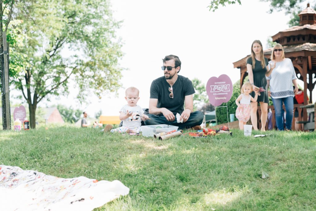 Parents with young child sitting on a hill |Mindfulness in parenting