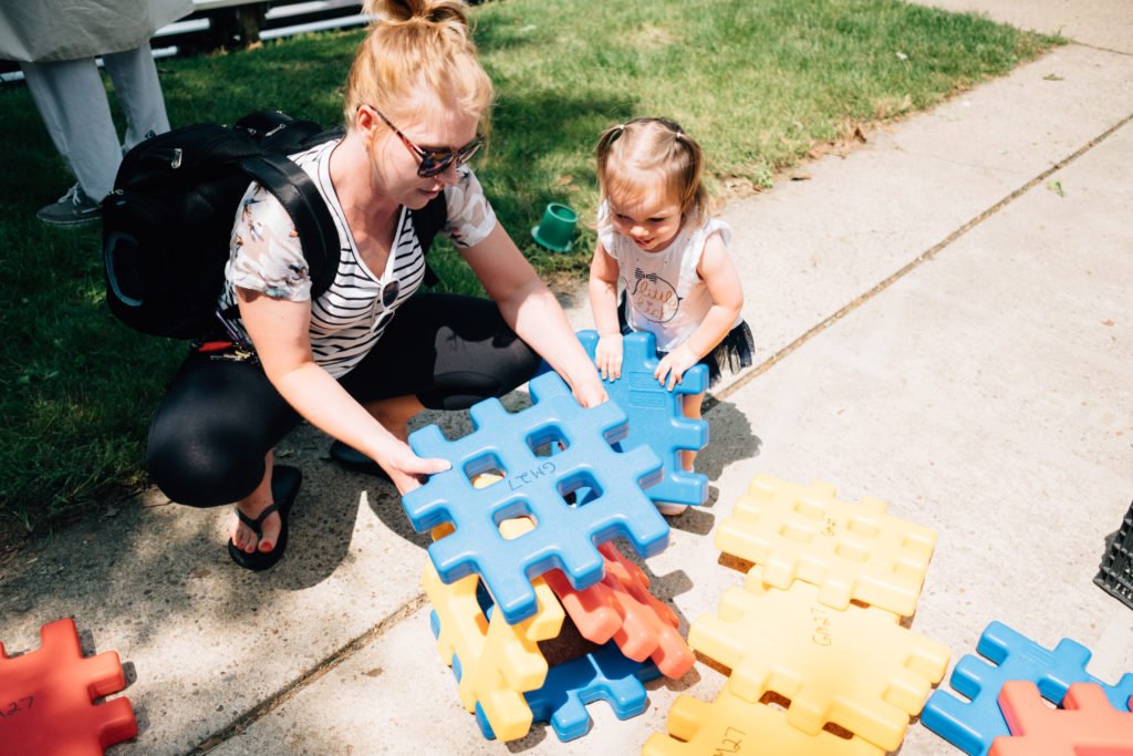 Caregiver playing building blocks with child on a sunny day | foster and adoptive families