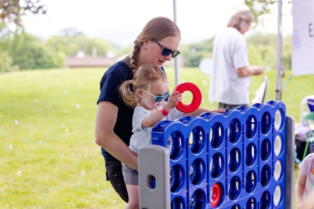 A mother playing giant Connect4 with her child | Can Guided Play Enhance Children’s Learning in Educational Settings