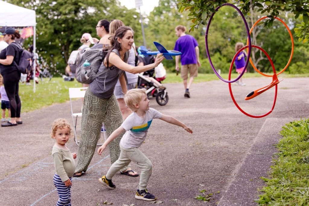 A mother throwing toys planes through hoops with her children | How to Promote Cognitive Development